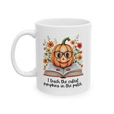 a white coffee mug with an image of a pumpkin reading a book and the words i teach