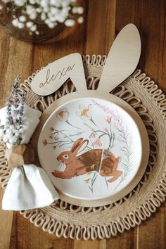 a plate with bunny ears on it sitting on a doily next to some flowers