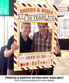 two men standing next to each other holding up a sign with cheers and beers written on it