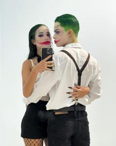 a man and woman dressed up in costumes taking a selfie with a cell phone