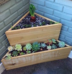 three wooden planters with succulents in them on the side of a building