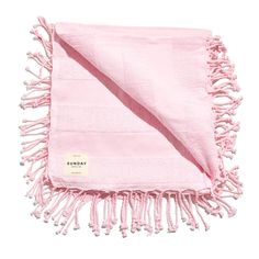 a pink blanket with fringes on it