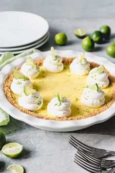 a lemon lime pie on a table with plates and utensils