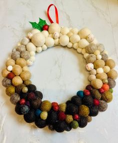 a christmas wreath made out of felt balls