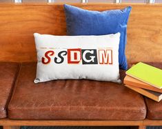 a couch with two books and a pillow that says seddgm on the front