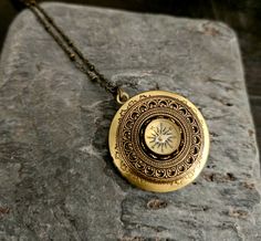 "A tiny working compass nestled in a round antiqued brass locket, framed in antiqued brass. Locket hangs from a long antiqued brass chain. Locket opens with two spaces as shown. Details: Locket measures 32mm in diameter Necklace measures 24 inches Locket is plated antiqued brass Chain is plated brass Back of locket is smooth as shown Please allow for possible slight color differences due to different settings on different screens. Want a shorter chain? Just leave me a \"note to seller\" at checkout with the length you would like. Thank you for shopping Delicate Industry :)" Classic Brass Medallion Locket Necklace, Elegant Brass Medallion Locket Necklace, Brass Medallion Locket Necklace For Memorial, Brass Medallion Locket Necklace With Cameo, Memorial Brass Medallion Locket Necklace, Compass Locket, Wanderlust Necklace, Chain Locket, Mom Gifts Jewelry