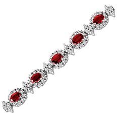 A spectacular present your special July birthday girl, this gemstone and diamond bracelet makes an unforgettable first impression. Crafted in cool 14K white gold, this romantic design features 6.0 x 4.0mm oval-shaped bright red rubies wrapped in frames of sparkling diamonds and alternating with marquise-shaped diamond links. Radiant with 4 cts. t.w. of diamonds and a brilliant buffed luster, this luxe 7.0-inch bracelet secures with a box clasp. Fine Jewelry White Gold Diamond Bracelet With Gemstones, Luxury Formal Bracelet With Halo Setting, Luxury Formal Bracelets With Halo Setting, Elegant White Gold Tennis Bracelet With Gemstones, Elegant White Gold Gemstone Tennis Bracelet, Elegant Red Bracelets With Brilliant Cut, Elegant Red Tennis Bracelet For Anniversary, Diamond Gemstone Bracelets For Anniversary, Anniversary Diamond Bracelet With Gemstones