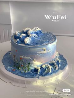 there is a blue cake with white frosting on the top and bottom tiers