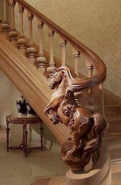 a wooden staircase with carved horses on the bannister and handrails in an elegant home