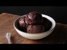 a bowl filled with chocolate ice cream on top of a wooden cutting board