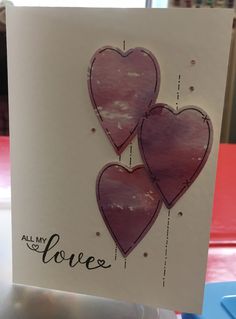 two pink hearts are on top of a card