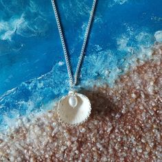 Embrace the beauty of the ocean with our handcrafted Seaside Elegance necklace, a stunning piece that captures the essence of the shore. This necklace features a natural seashell pendant, carefully selected for its unique shape and intricate patterns, paired with a lustrous freshwater pearl that adds a touch of elegance. Each necklace is lovingly handcrafted, ensuring that no two pieces are exactly alike--just like the treasures you find on the beach. The combination of organic elements and timeless pearls creates a perfect harmony, making this necklace a versatile accessory that can complement any outfit, whether you're dressing up for a special occasion or adding a touch of coastal charm to your everyday look. Features: Natural Seashell: Handpicked for its distinctive beauty, bringing th Beach Jewelry With Pearl Pendant In Shell Shape, Shell-shaped Sterling Silver Jewelry For Beach, Shell Jewelry With Pearl Pendant, Shell-shaped Pearl Pendant Jewelry For Beach, Silver Shell-shaped Ocean-inspired Jewelry, Ocean-inspired Shell Necklace With Lobster Clasp For Gift, Ocean-inspired Shell-shaped Necklaces With Lobster Clasp, Beach Shell With Pearl Pendant, Beach Shell-shaped Shell With Pearl Pendant