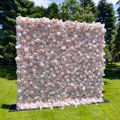 a large flower covered wall in the middle of a field