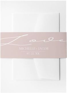 a wedding card with the word love on it in white ink and pink foiling