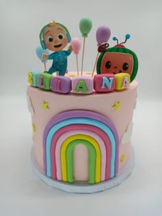 a birthday cake decorated with an image of a child's name and rainbow decorations