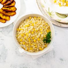 a bowl filled with rice and corn next to plates of grilled pineapples