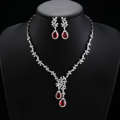 a necklace and earring set with red stones on a mannequin neckline