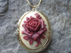 "Beautiful cameo locket The cameo is a gorgeous flawless rose with a single bud. The bronze or gold plated locket is victorian style with beautiful Victorian etching on both the front and back, 2\" long, the last two photos are for sizing, not color, (I can also make this in silver, rose gold or antiqued silver, please do leave a note at checkout). It can hold two photos and/or a treasured keepsake Pass down from generation to generation The bronze locket comes with a matching 24\" rolo link cha Unique Locket, Everyday Necklaces, Cameo Jewelry, Music Boxes, Rose Rouge, Maroon Red, Rose Gold Foil, Everyday Necklace, Traditional Jewelry