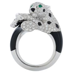 Panthere De Cartier ring in 18k white gold, accompanied by Cartier box. This Cartier ring features a panther covered in approximately 1.47 carat of pave set round brilliant cut diamonds with emerald eyes and onyx accents. The ring is approximately 13.5mm at its widest point and the top of the panther's head sits 12mm above the finger while being worn. Size 50 (5.25 US) Numbered and signed Cartier, has French hallmarks. Cartier Panther Ring, Cartier Panther, Panther Ring, Cartier Diamond, Rare Diamond, Smaragd Ring, Cartier Panthere, Onyx Jewelry, Cartier Jewelry