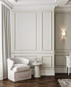 a white chair sitting next to a table on top of a hard wood floor in a room