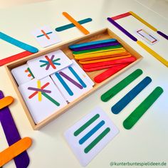 a wooden box filled with different colored crayons and magnets on top of a table