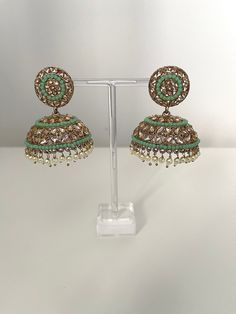 A pair of gold polki stoned jhumki/ jhumka earrings.  These come in pink/ green/ mint and light pink  Everyone needs a good pair of jhumki/ jhumka earrings that you can wear for all occasions and these are no exception.  Please not for hygiene reasons we do not offer a refund of exchanges. Luxury Green Bollywood Jhumkas, Green Jhumkas For Wedding And Eid, Festive Green Chandbalis For Party, Green Jhumkas With Stone Work, Traditional Green Jhumkas For Eid, Green Chandbalis With Latkans For Party, Festive Green Round Jhumkas, Green Danglers With Stone Work For Party, Party Green Danglers With Stone Work