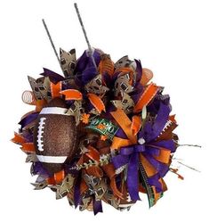 the football wreath is decorated with purple, orange and silver streamers