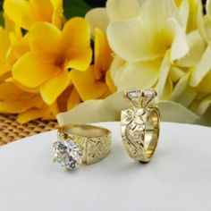 two wedding rings sitting on top of a table next to flowers