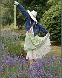 a woman in a dress and hat is standing in the middle of lavenders with her arms outstretched