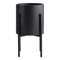 a black planter sitting on top of a wooden stand