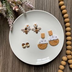 a white plate topped with three pieces of food next to a beaded necklace and earrings