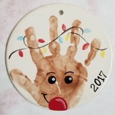 a christmas ornament with a hand print on it's face and the year 2013