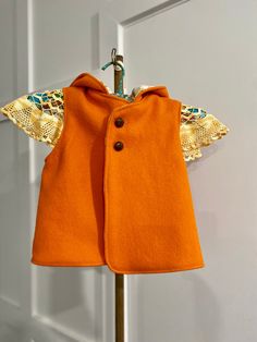 "Super cute child's vest , size 4  Perfect for extra layer of warmth ,while allowing freedom of movement to play and explore.Very handy to layer up or down in Fall/ Autumn / Spring /Winter weather.  This super cute vest is made with a delightful vintage fabric outer featuring bright orange pure wool  blanket with a brushed cotton floral print inner. You can reverse this jacket if you wish. It has a sweet pointed pixie hood to keep ears and head cosy on cold days , with two buttons at chest to se Winter Orange Sleeveless Vest, Orange Sleeveless Winter Vest, Gender Neutral Style, Woollen Blankets, Kids Vest, Crochet Vintage, Vest Pattern, Orange Pattern, Vest Outfits