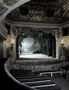 an ornately decorated auditorium with pews and chandeliers on either side of the stage