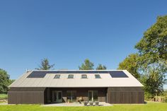 a house with a metal roof and two windows on the top floor, surrounded by trees