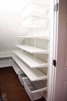 an empty pantry with white shelves and drawers