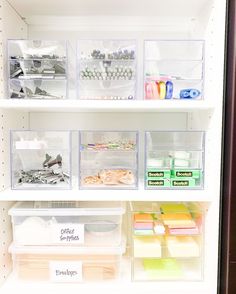 an organized refrigerator with plastic bins and labels on the shelves in front of it