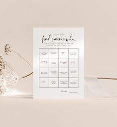 a white wedding seating chart with flowers on the side