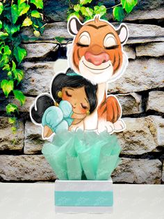 a paper cutout of a tiger hugging a girl in front of a stone wall