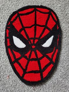 a close up of a spiderman rug on the floor with eyes drawn in it