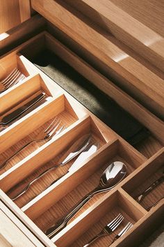 an open drawer with silverware in it