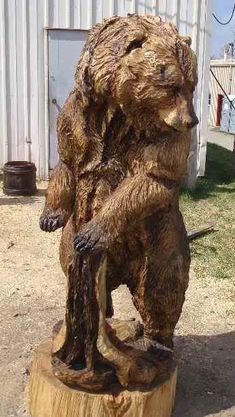 a bear statue sitting on top of a tree stump