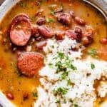 a white bowl filled with beans, rice and sausage