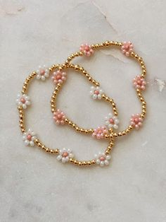 These are the most adorable daisy beaded bracelets made with your choice of gold filled or gold-plated beads and choice of pink or white daisy's. The daisies are made out of Czech Glass Beads and are perfectly dainty and adorable, especially for spring! Additional option is to just do seed beads, rather than gold plated or gold-filled beads. Pink And Gold Beaded Bracelet, Pink And White Beaded Bracelets, White And Gold Beaded Bracelet, Spring Beaded Bracelets, Aesthetic Bead Bracelets, Daisy Beaded Bracelets, Bracelets With Pearls, Spring Bracelets, Glass Bead Jewelry