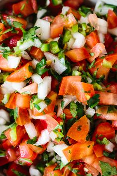 a bowl filled with chopped up vegetables and garnished with cilantro sauce