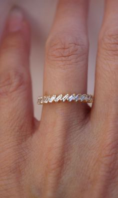 a woman's hand with a wedding band on it, and the ring is made out of white gold