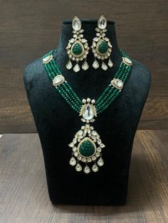 Make a statement with this exquisite green Kundan long necklace. Featuring a Victorian-inspired Polki pendant with a dazzling emerald, this Sabyasachi-inspired piece is crafted in premium dual-tone Jadau. Perfect for any special occasion, it combines timeless elegance with luxurious craftsmanship to enhance your unique style. *𝐏𝐑𝐎𝐃𝐔𝐂𝐓 𝐃𝐄𝐓𝐀𝐈𝐋* * Material: Brass * Plating: Gold Plated * Stone: Kundan, Polki & Emerald. *𝐃𝐈𝐌𝐄𝐍𝐒𝐈𝐎𝐍𝐒* *Necklace* * Weight: 71 gm * One Side Length Elegant Green Emerald Necklace With Stone Work, Elegant Green Stone Work Necklaces, Elegant Green Stone Work Necklace, Fusion Style Green Bridal Necklace With Hand Set Details, Fusion Style Green Bridal Necklace With Hand Set, Green Fusion Bridal Necklace With Intricate Design, Elegant Heavy Green Emerald Necklace, Green Kundan Necklace With Intricate Fusion Design, Green Kundan Necklace With Intricate Design