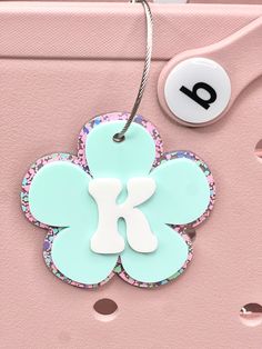 "These personalized tags are versatile and can be used as charms for various items such as backpacks, diaper bags, pool bags, or even as car charms. They are made of layered 1/8\" acrylic. Each tag measures 3.5\" in size. Please NOTE: it is important to handle item with care as acrylic can break if dropped or hit on a hard surface. HOW TO ORDER: 1. Choose the acrylic color for the background/back layer in the first drop down menu  2. Choose color for acrylic for the top daisy in the 2nd drop down menu  3. Add your initial on the personalization box We thank you for stopping by! you are supporting a mother daughter duo in our home based studio in Illinois!" Personalized Green Travel Bag, Personalized Playful Blue Bag, Playful Personalized Blue Bag, White Travel Bags With Keychain, White Travel Bag With Keychain, Cute Personalized Travel Bags, Playful Customizable Bags For Travel, Personalized Pink Luggage Tag For Travel, Personalized Bag Tags