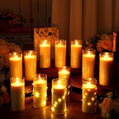 many lit candles are arranged on a table