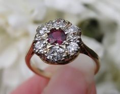 Free shipping and complementary resize*! This gorgeous ring is designed with a central cherry natural ruby set within a surround of eight smaller diamond 'petals'. The .5 carat ruby is exceptional in colour, and has incredible clarity. The sparkling old cut diamonds total 0.78 carat. Rubies are arguably one of the rarest gem stones on earth and an antique ruby with old cut diamonds (set in this design) is particularly coveted by collectors and brides alike.... You'll struggle to find another. Go Classic Cluster Ruby Ring, Classic Ruby Ring With Rose Cut Diamond Cluster, Cluster Ruby Diamond Ring With Center Stone, Cluster Ruby Ring With Center Stone, Red Diamond Cluster Ring With Halo Setting, Classic Ruby Cluster Ring, Classic Ruby Cluster Ring With Center Stone, Classic Cluster Ruby Ring With Center Stone, Cluster Ruby Diamond Ring